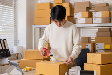 Small business warehouse scene of worker apply shipping label on parcel and taping cardboard box, organizing delivery tasks, order preparation and maintaining efficient packing workflow, multitasking