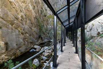 Modern Covered Wooden Walkway and Steel Structure Built Along a Rocky River Gorge and Limestone Cliff