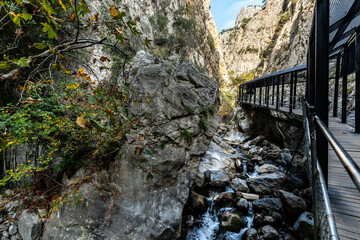 Modern Elevated Wooden Walkway and Steel Structure Alongside a Rocky Mountain River Rushing Through a Limestone Gorge