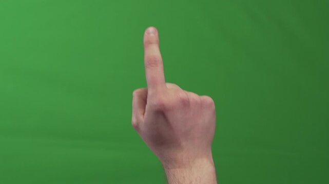 Close up of human hand with extended index finger imitating touch and swipe gestures on an imaginary digital interface. Isolated on green chroma key background for compositing.