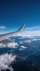 Fototapeta premium Clear Blue Sky View of Airplane Wing Cutting Across Scenic Landscape with Clouds