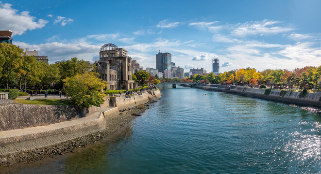 View of the banks of the Motoyasu River with the iconic ruins of the Genbaku dome prominent in the skyline, Hiroshima, Chugoku, Honshu, Japan