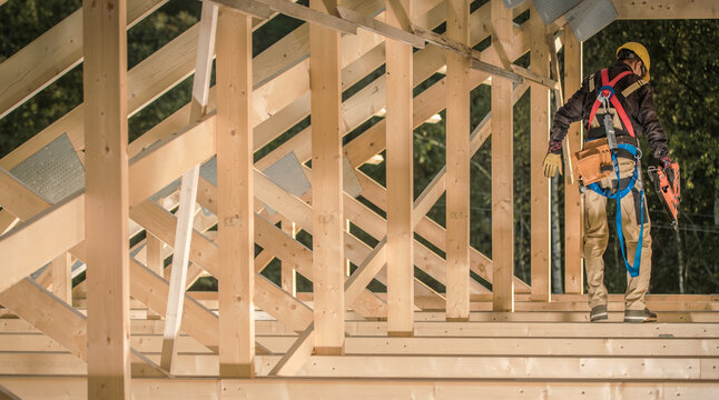 Construction Worker Builds House Frame With Wooden Beams and Safety Gear - Powered by Adobe