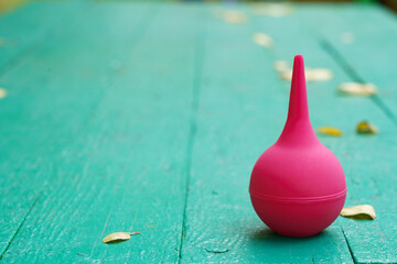 Pink medical bulb on a wooden green background