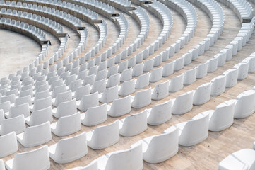 Fototapeta premium Seats arranged in a circular pattern at an outdoor venue for an event in a city during daytime