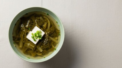 Bowl of traditional Asian green leafy vegetable soup garnished with green
