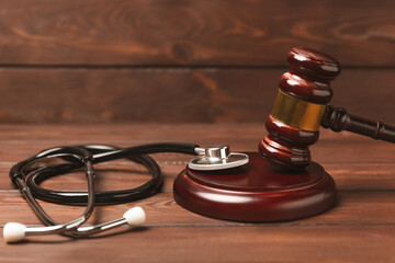 A stethoscope and hammer on a desk. Medical malpractice, personal injury lawyer, and healthcare...