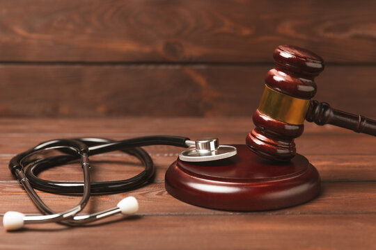 A stethoscope and hammer on a desk. Medical malpractice, personal injury lawyer, and healthcare legal aspects concept.Lawyer.Legal definition of medical negligence. Law concept.Healthcare and Medicine