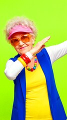 Senior woman dances in colorful outfit with vibrant background