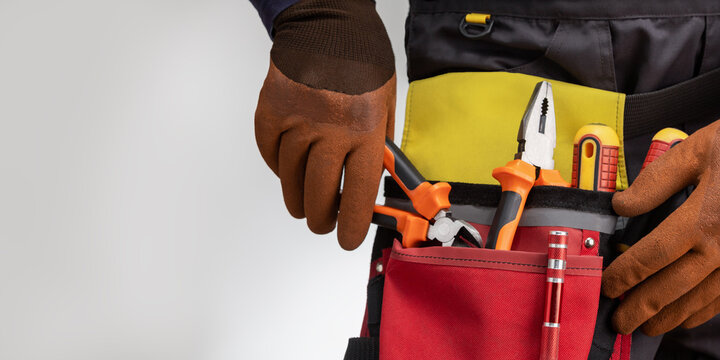 Close-up of tools belt on electrician worker. Banner with copy space.