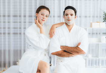 Obraz premium Serene modern daylight ambiance of spa salon, couple customer indulges in rejuvenating with facial skincare mask. Facial skin treatment and beauty cosmetology procedure for face. Quiescent