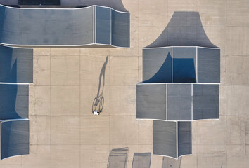 Obraz premium Biker performing tricks in a urban skatepark with ramps and shadows