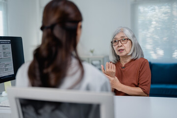 Senior woman discussing wrist pain with doctor during consultation