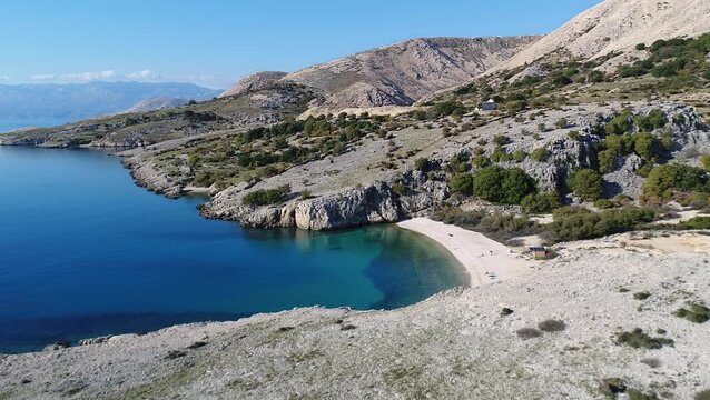 Drone footage showing Ba&scaron;ka bay with turquoise water, coastal cliffs and dry rocky terrain on the island of Krk, Croatia.