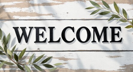 Welcome Sign on Rustic White Wooden Surface with Green Leaf Branches