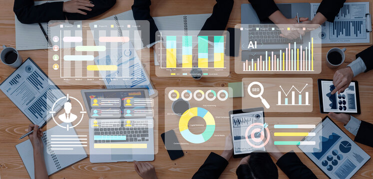 A diverse business team engages in analysis and collaboration, utilizing digital interfaces and data visualizations in a modern office setting. Gantry - Powered by Adobe