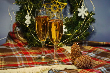 Two glasses of champagne on the background of Christmas decorations and garlands. Warm light. Festive mood, new year.