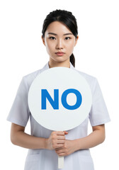 Young asian woman in lab coat holds a white 'NO' sign, serious and focused, direct eye contact, against transparent studio background with copy space, professional refusal concept