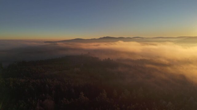 Aerial view of a sea of fog over morning countryside under clear sky