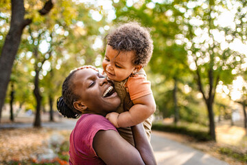 Fototapeta premium Joyful moments shared between mother and child in a sunlit park