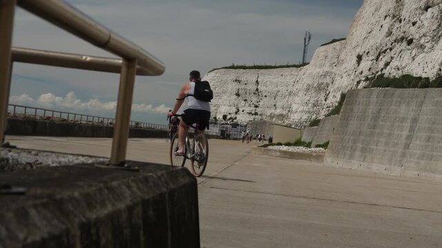 Cyclist Riding Along the Cliffs on Brighton Seafront