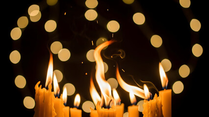 Group of glowing candles with bright flickering flames against a warm golden bokeh background