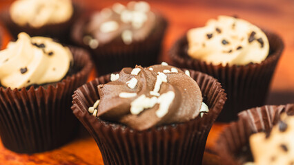 Assorted chocolate and caramel mini cupcakes, beautifully decorated and moist. Bite-sized sweet treats perfect for parties, celebrations, and dessert tables.