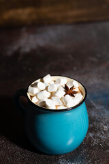 mug of hot chocolate with marshmallows on dark background, vertical top view