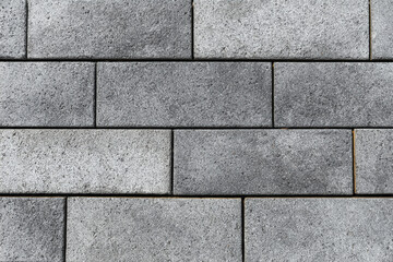 Obraz premium Textured grey concrete paving stones arranged in a brick pattern