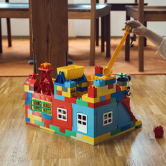 Fototapeta premium colorful lego house with crane, playful construction and creativity in action