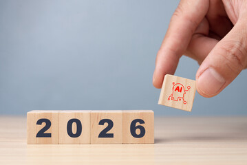 Hand placing an AI wooden cube next to year 2026. Conceptualizing future technology trends, artificial intelligence progress, and digital innovation.