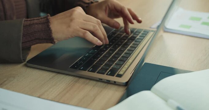 Professional composing plan with careful keystrokes on laptop