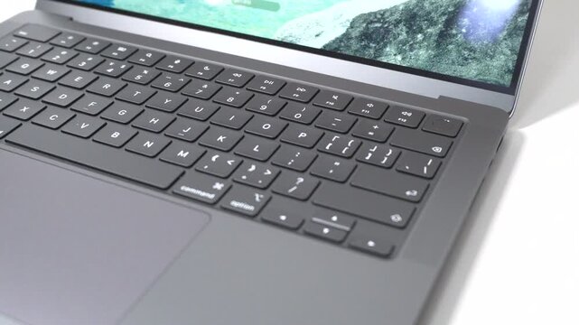 The camera pans across, capturing a close-up shot of the laptop.