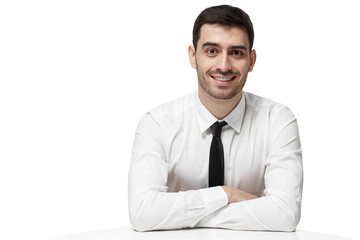 Smiling businessman sitting at white table with arms crossed looking at the camera