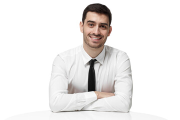 Smiling young businessman sitting at a white table with arms crossed looking at the camera