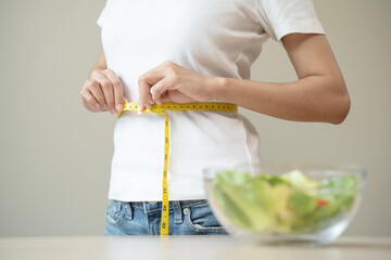 Close-up woman measuring her shape after weight loss session.