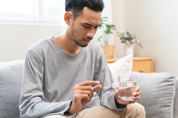 Close-up a medicine tablet in young man hand taking painkiller
