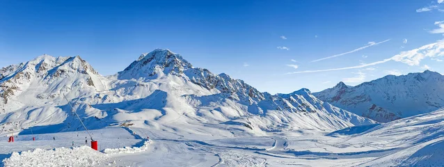 Fotobehang Alpen panorama on ski resort  in tarentaise valley, savoie with snowy mountain range and ski slope under blue sky  © coco