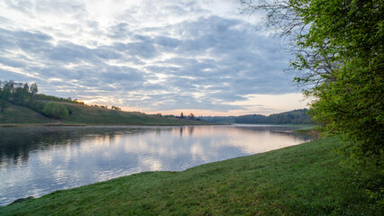 Obraz premium Morning sunrise landscape of foggy river with wet grass forest and sunrise