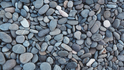 Smooth round pebbles texture background. Pebble sea beach close-up, dark wet pebble and gray dry pebble. High quality photo