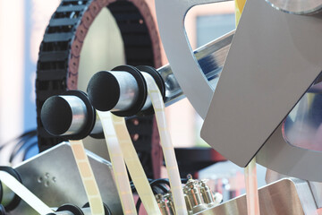 Fragment of the conveyor of sticking labeling machine. Abstract industrial background.