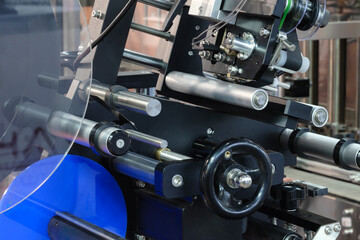 Fragment of the conveyor of sticking labeling machine. Abstract industrial background.