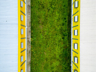 Modern agro-industrial complex top view. Flying a drone over a large chicken farm, raising broiler chickens for meat. Rows of chicken coops and silver grain silos. © Pokoman