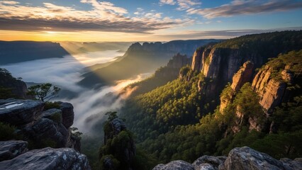 Majestic sunrise painting the rugged cliffs and misty valley with golden hues, showcasing the serene beauty of nature's awakening at dawn, a breathtaking panoramic landscape