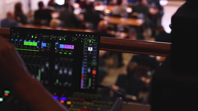 View of lighting engineer operator working on mixing console workplace during live event concert on stage show broadcast, light mixer controller panel, sound technician  with professional equipment
