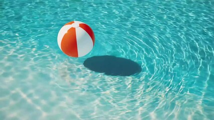 Bright beach ball floats on clear water surface during sunny day at a swimming pool, inviting fun and leisure for anyone nearby who enjoys warm weather and outdoor activities