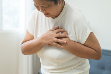 Chest pain, attack chest, emergency heartbeat asian senior woman holding hand on chest, suffering symptom from pain, heart disease problem of aged anxiety cardiac. Health care of cardiology concept.
