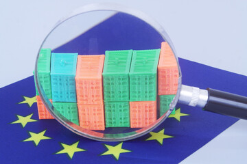 Obraz premium Many cargo containers under magnifying glass on EU flag. European Union import and export concept.