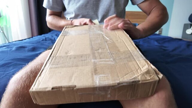 Man wraps a cardboard box with packing tape