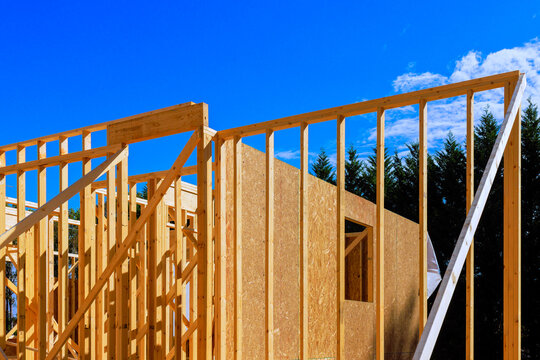 Workers are busy framing new wooden building is beams